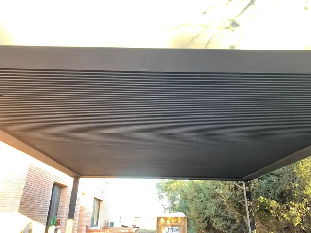 Pérgola metálica con cubierta sobre patio en La Tablada — Grupo Escobar